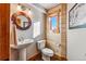 Cozy powder room with pedestal sink, wood paneling, and natural light at 351 Kimmes Ln, Breckenridge, CO 80424
