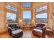 Cozy sitting area with wood paneling, large windows capturing mountain views, and comfortable leather chairs at 351 Kimmes Ln, Breckenridge, CO 80424