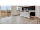 Open kitchen with island, dark cabinets, and sliding glass doors to backyard at 5700 Ranch St, Mead, CO 80504