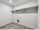 Laundry room with wood look flooring and shelving at 5700 Ranch St, Mead, CO 80504