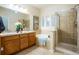 Bathroom featuring a dual sink vanity, tub, and glass-enclosed shower for comfort at 7777 E 23Rd Ave # 401, Denver, CO 80238