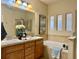 Bathroom featuring a dual sink vanity, tub, and ample natural light through translucent windows at 7777 E 23Rd Ave # 401, Denver, CO 80238
