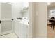 A laundry room with a white washer and dryer. A wire basket is placed on top of the machine at 7777 E 23Rd Ave # 401, Denver, CO 80238