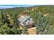 Aerial shot showing a home with a deck surrounded by evergreens and forest, providing privacy at 251 Ridgeview Ln, Boulder, CO 80302