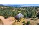 Aerial view of a home surrounded by a dense forest on a sunny day, showcasing its elevated location at 251 Ridgeview Ln, Boulder, CO 80302
