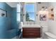 Modern bathroom featuring blue tiled shower, floating vanity, and a window offering natural light and views at 251 Ridgeview Ln, Boulder, CO 80302