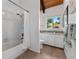 Bright bathroom with bathtub and shower, complemented by a rustic vanity and wooded landscape views at 251 Ridgeview Ln, Boulder, CO 80302