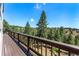 Open wooden deck overlooking vast scenery filled with tall pine trees on a sunny day at 251 Ridgeview Ln, Boulder, CO 80302