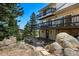 Multi-level home with large, wooden decks, rock landscaping, and nestled in a forest-like area at 251 Ridgeview Ln, Boulder, CO 80302