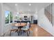 Open concept kitchen with stainless steel appliances, an island, and a dining table by large windows at 251 Ridgeview Ln, Boulder, CO 80302