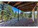 Covered stone patio surrounded by trees offering serene views and outdoor living space at 251 Ridgeview Ln, Boulder, CO 80302