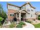 Two-story townhome with stone and siding exterior, patio, and walkway at 1879 S Buchanan Cir, Aurora, CO 80018