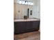 Bathroom with double sinks, dark cabinets, and a large mirror at 22345 E Bailey Pl, Aurora, CO 80016