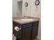 Bathroom sink with dark cabinets, a large mirror and wood-look flooring at 22345 E Bailey Pl, Aurora, CO 80016
