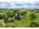 An aerial view of a sprawling green acreage with a home, outbuildings, and trees at 12798 Tomahawk Rd, Parker, CO 80138