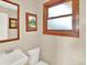 Powder room with white fixtures, framed mirror, and a wooden-framed window at 12798 Tomahawk Rd, Parker, CO 80138