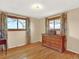 Bright bedroom showcasing hardwood floors, neutral walls, with natural light streaming in from two windows with floral curtains at 12798 Tomahawk Rd, Parker, CO 80138