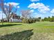 Spacious backyard with lush lawn and mature trees, showcasing the home's exterior and natural surroundings at 12798 Tomahawk Rd, Parker, CO 80138