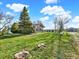 Expansive grassy yard featuring mature trees, adjacent to a single-story section of the home at 12798 Tomahawk Rd, Parker, CO 80138
