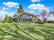 Exterior view of the home featuring large windows, a deck, and a well-maintained lawn at 12798 Tomahawk Rd, Parker, CO 80138
