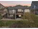 Back exterior view of the home with a large deck and lower patio, offering a perfect outdoor living and entertaining space at 27423 E Euclid Dr, Aurora, CO 80016