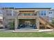 Backyard featuring an outdoor lounge area, stairs to an upper deck, and green grass at 27423 E Euclid Dr, Aurora, CO 80016