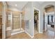 A tiled walk-in shower sits adjacent to a walk-in closet in this primary bathroom at 27423 E Euclid Dr, Aurora, CO 80016