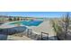 A community pool is ready for the summer in this aerial shot, complete with shade structures and views of the nearby lake at 27423 E Euclid Dr, Aurora, CO 80016