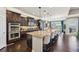 Gourmet kitchen with a large island, pendant lighting, dark cabinetry, stainless steel appliances, and a breakfast bar at 27423 E Euclid Dr, Aurora, CO 80016