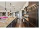 Modern kitchen featuring a granite island, stainless steel appliances, dark wood cabinetry, and hardwood floors at 27423 E Euclid Dr, Aurora, CO 80016