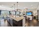 Gourmet kitchen with a large island flowing into an open-concept living and dining area with beautiful hardwood floors at 27423 E Euclid Dr, Aurora, CO 80016