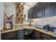 This kitchenette features granite countertops, dark wood cabinets, and a modern wine rack at 27423 E Euclid Dr, Aurora, CO 80016