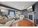 Open-concept living area with fireplace, wood floors, and comfortable furnishings at 27423 E Euclid Dr, Aurora, CO 80016