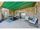 Covered patio with stone pillar construction, outdoor furniture, and sliding glass door entry at 27423 E Euclid Dr, Aurora, CO 80016