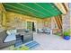 Covered stone patio with comfortable seating, ceiling fan, and easy access to the backyard at 27423 E Euclid Dr, Aurora, CO 80016
