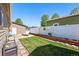 Well-maintained backyard with green lawn, storage shed, and white fence at 6231 Indian Paintbrush St # 214, Frederick, CO 80530