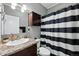 Updated bathroom featuring dark wood vanity, granite counters, and a black and white striped shower curtain at 6231 Indian Paintbrush St # 214, Frederick, CO 80530