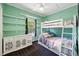 Bedroom featuring a bunk bed, built-in shelves, and green-painted walls at 6231 Indian Paintbrush St # 214, Frederick, CO 80530