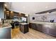 Spacious kitchen featuring stainless appliances, granite counters, kitchen island, and wood laminate floors at 6231 Indian Paintbrush St # 214, Frederick, CO 80530