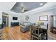 An open-concept living room with wood floors, modern furnishings, a ceiling fan, and a tray ceiling at 6231 Indian Paintbrush St # 214, Frederick, CO 80530