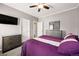 Comfortable primary bedroom featuring grey walls and a purple duvet with decorative pillows and TV at 6231 Indian Paintbrush St # 214, Frederick, CO 80530