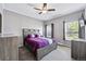 Comfortable primary bedroom featuring grey walls and a purple duvet with decorative pillows at 6231 Indian Paintbrush St # 214, Frederick, CO 80530