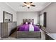 Neutral bedroom with a ceiling fan, a wooden dresser, and a purple duvet with decorative pillows at 6231 Indian Paintbrush St # 214, Frederick, CO 80530