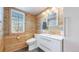 Rustic bathroom featuring wood paneled walls, a modern vanity, and updated fixtures at 7464 Shoreham Pl, Castle Pines, CO 80108