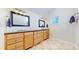 Bright bathroom featuring a wooden vanity with dual sinks and granite countertops, creating a luxurious experience at 7464 Shoreham Pl, Castle Pines, CO 80108