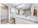 Bright bathroom featuring a granite countertop, sink, and large mirror at 7464 Shoreham Pl, Castle Pines, CO 80108