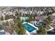 Aerial view of the community pool and tennis courts surrounded by lush greenery and trees at 7464 Shoreham Pl, Castle Pines, CO 80108