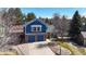 Charming two-story home featuring a brick and blue-sided facade, two-car garage, and mature landscaping at 7464 Shoreham Pl, Castle Pines, CO 80108