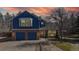 Charming two-story home featuring a brick and blue-sided facade, two-car garage, and mature landscaping at 7464 Shoreham Pl, Castle Pines, CO 80108