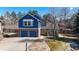 Charming two-story home featuring a brick and blue-sided facade, two-car garage, and mature landscaping at 7464 Shoreham Pl, Castle Pines, CO 80108